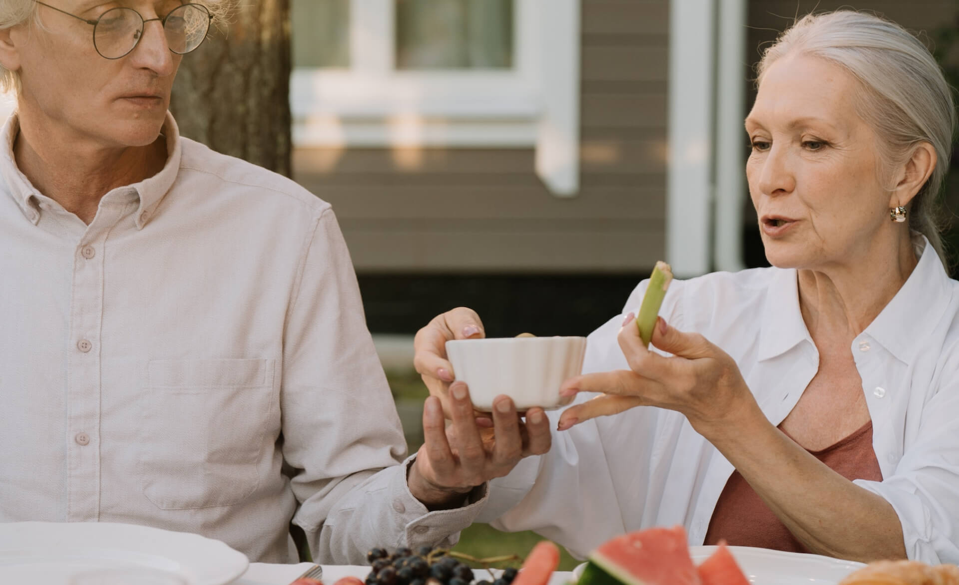 older couple sat together eating and drinking