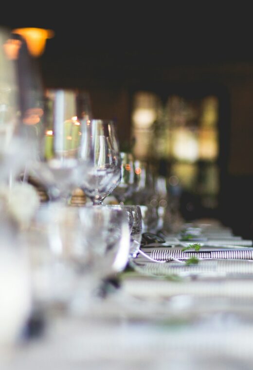 a table with glasses and plates on welcoming guests dressed by employees who work with a catering staffing agency