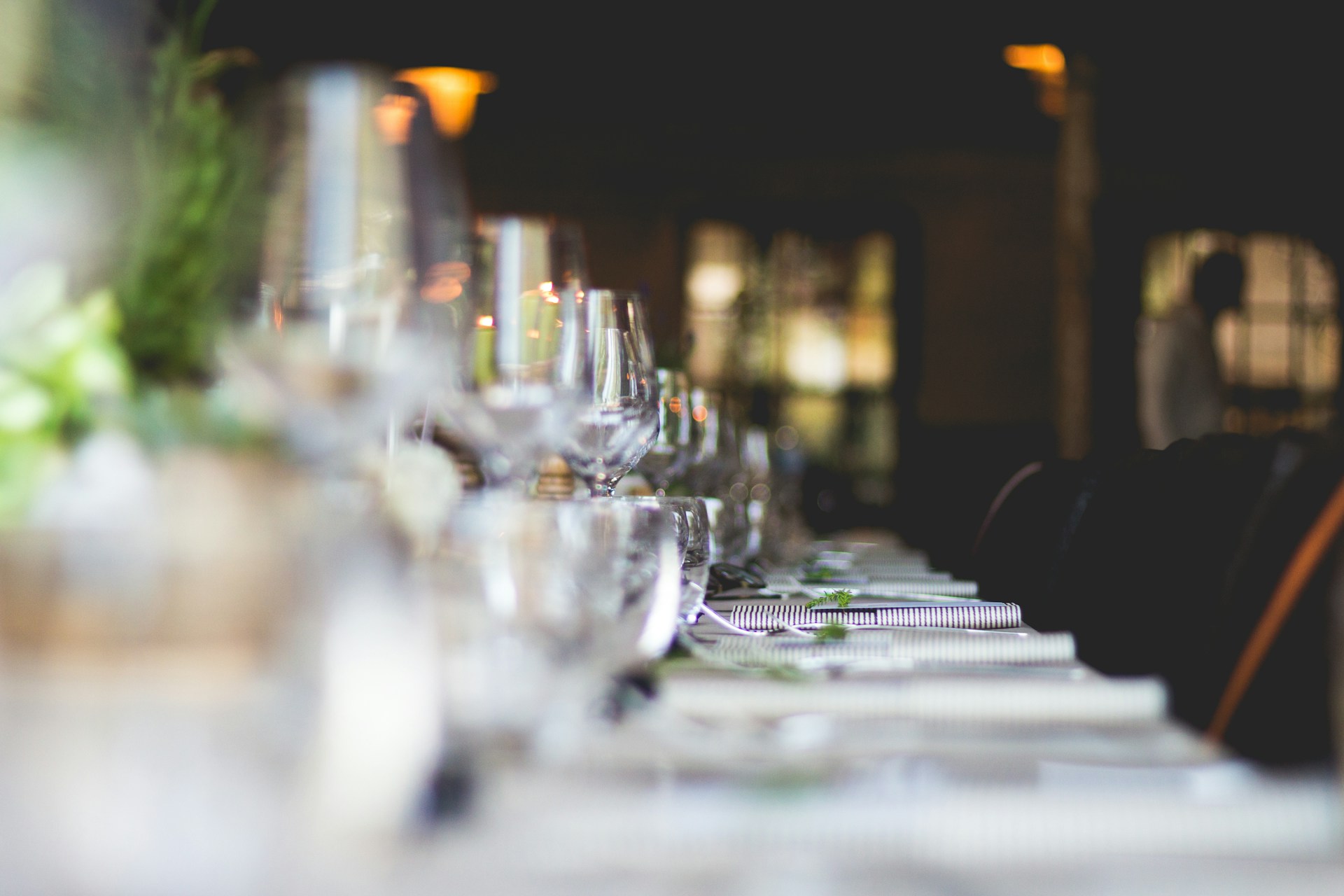 a table with glasses and plates on welcoming guests dressed by employees who work with a catering staffing agency