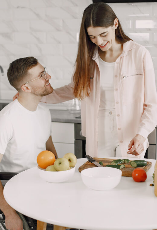 a man and woman at a table preparing vegetables