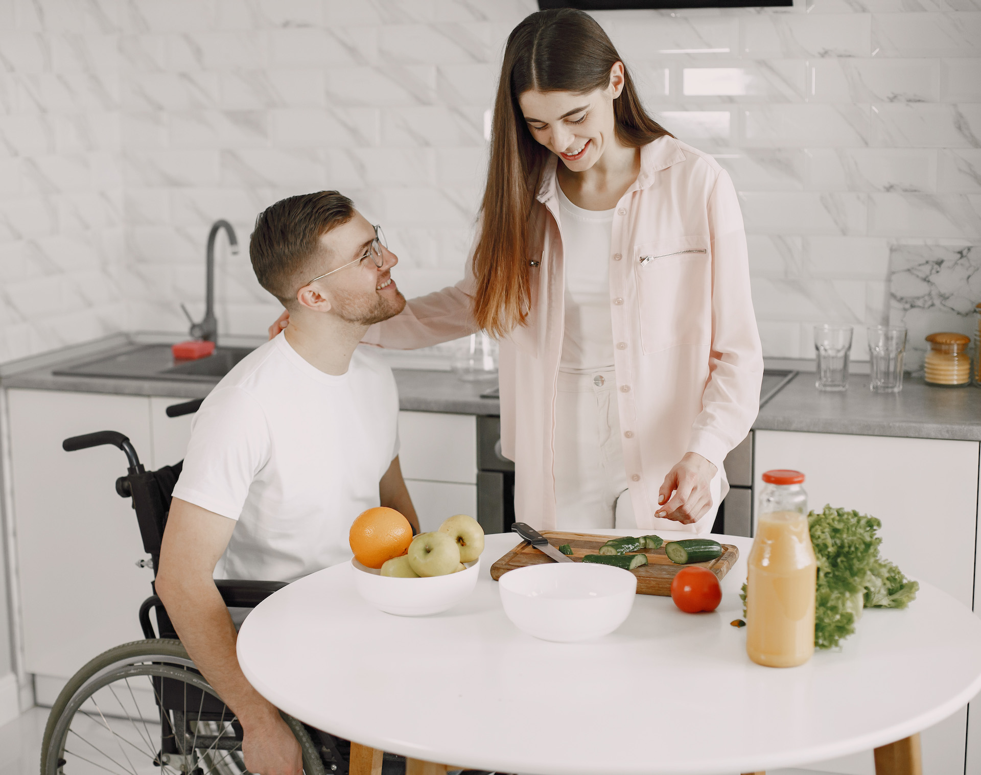 a man and woman at a table preparing vegetables