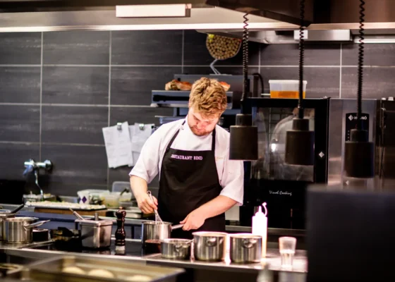 a cook in a modern kitchen preparing a meal