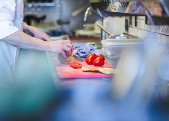 image showing a caterer chopping up tomatoes in a kitchen. wondering what catering in a care home is like? read more