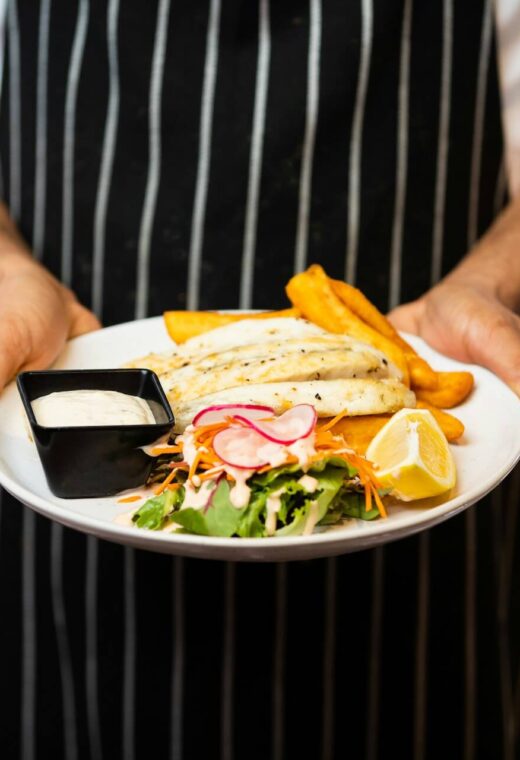 zoomed in image of a chef holding a dish that he has prepared