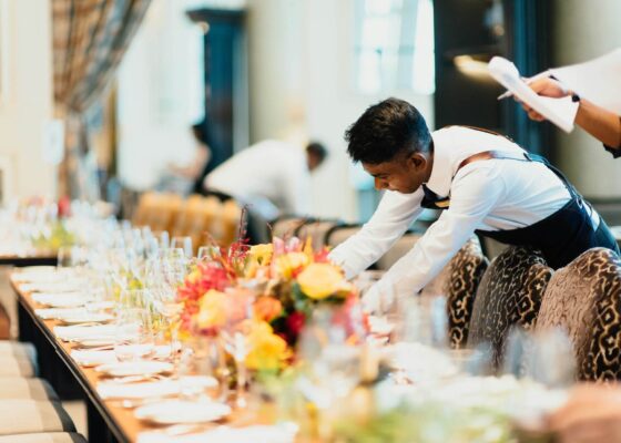 a staff member setting a table illustrating the advantages of using a catering staffing agency