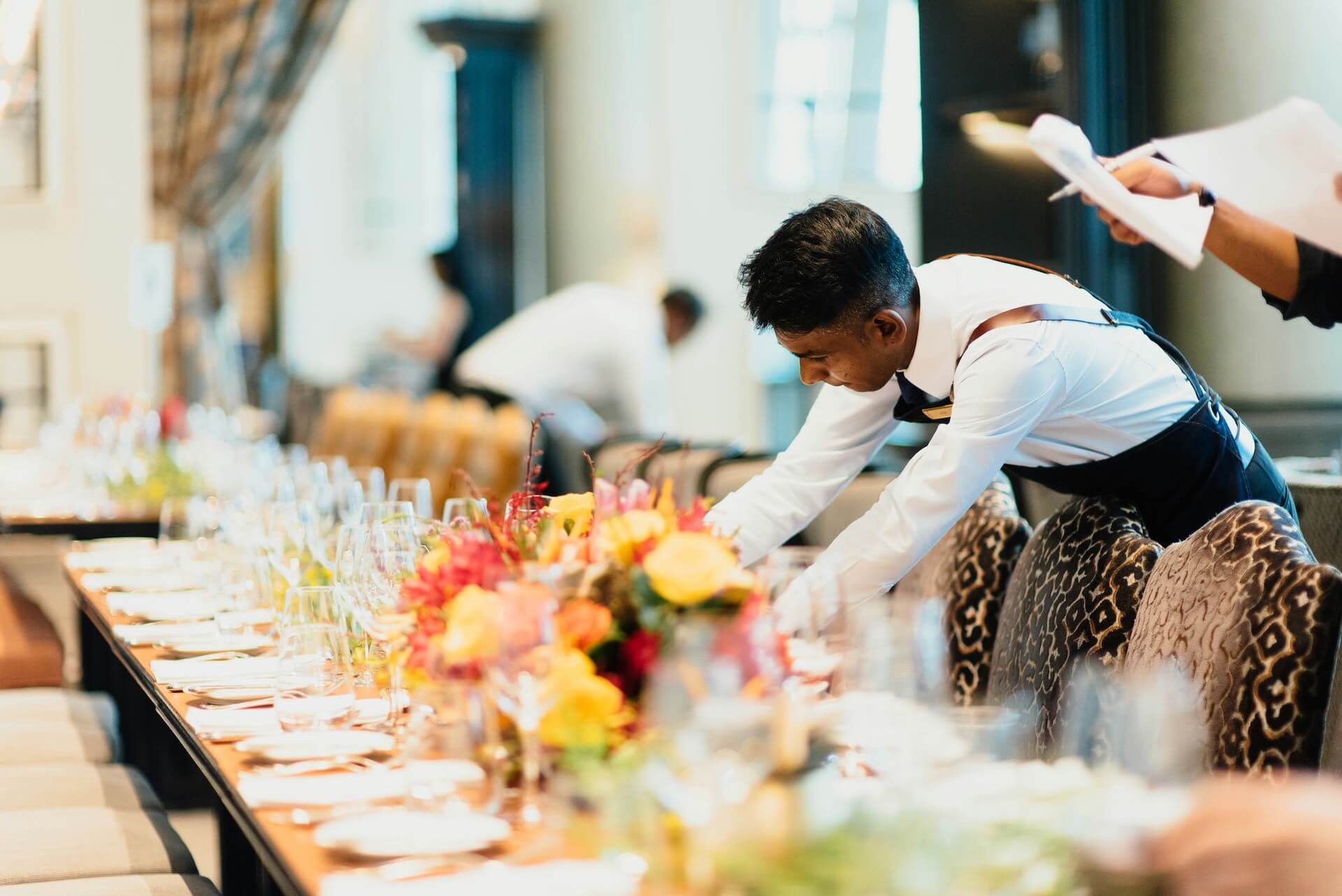 a staff member setting a table illustrating the advantages of using a catering staffing agency