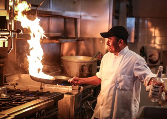 image of a chef cooking with fire in a frying pan