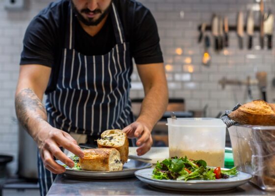 image of a caterer dishing up food in a kitchen for the what to expect from catering staff